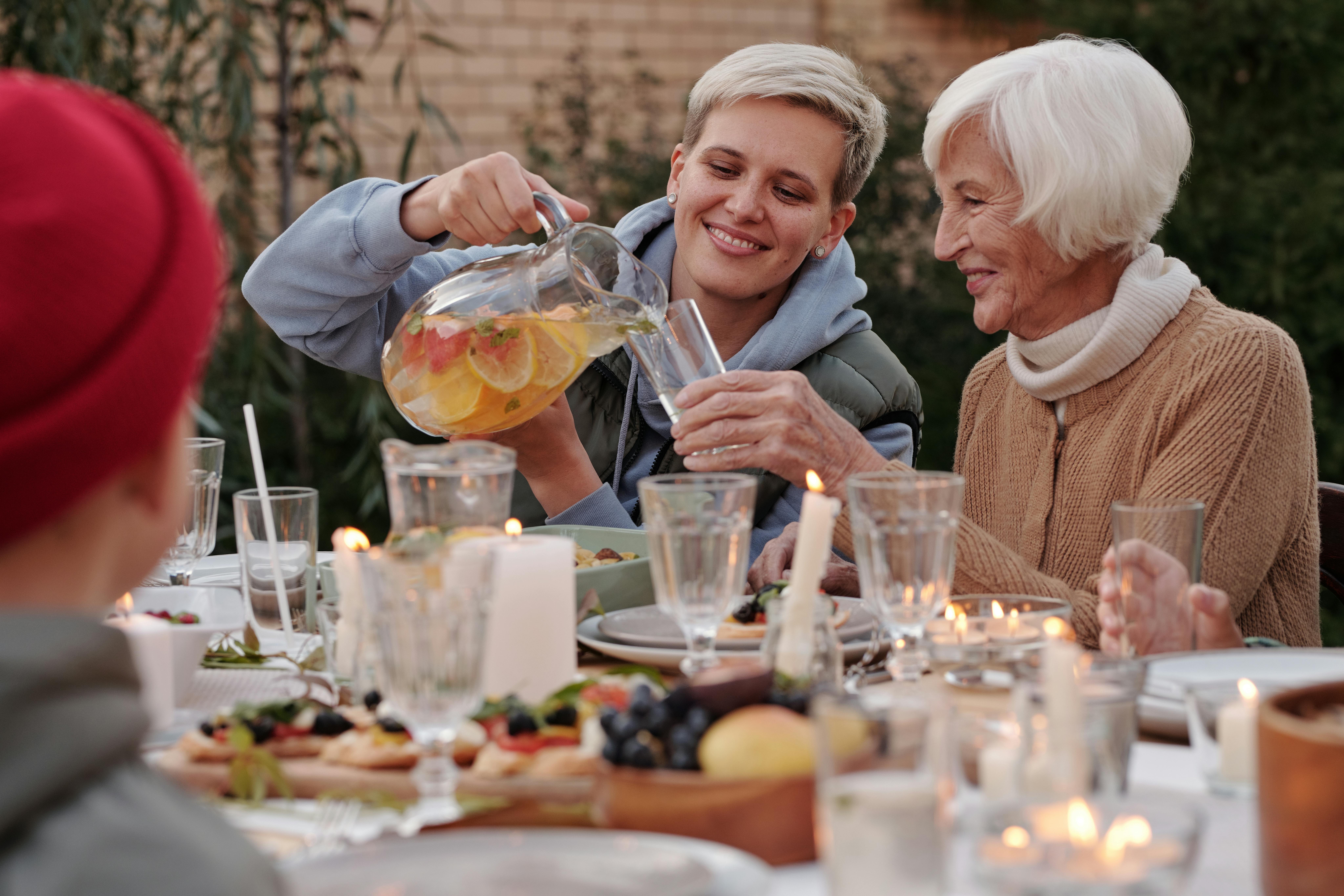 senior with adult child talking at a table with drinks