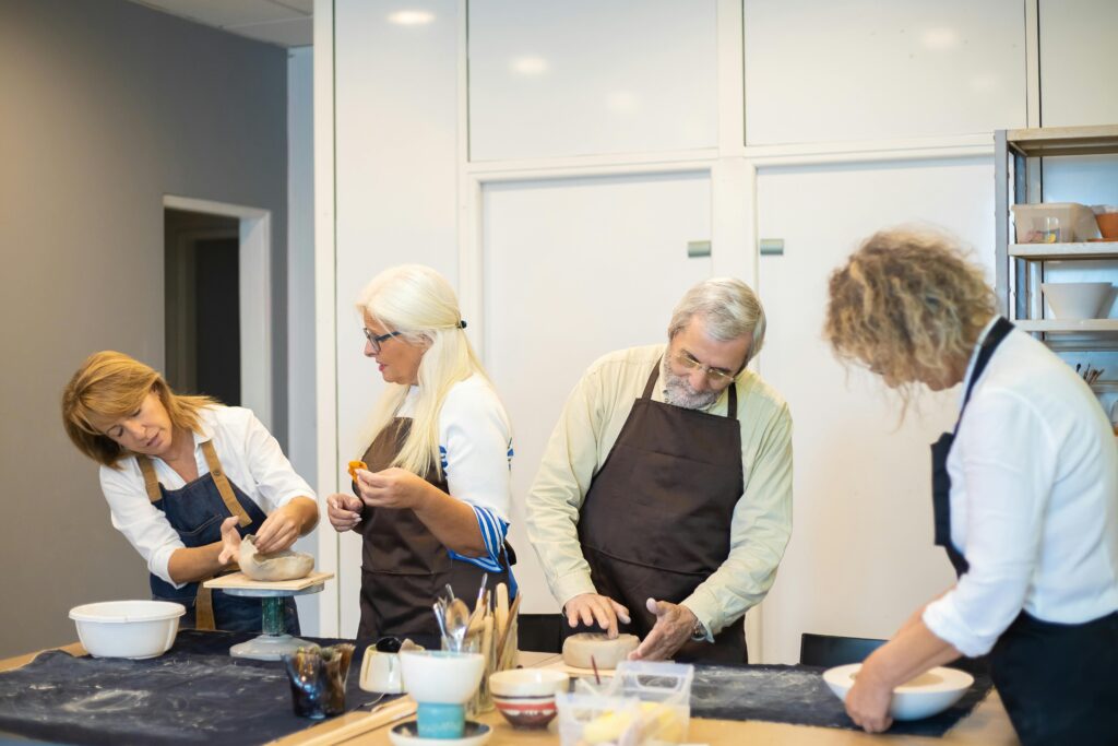 Active seniors participating in a group art class inside a senior living community activity room