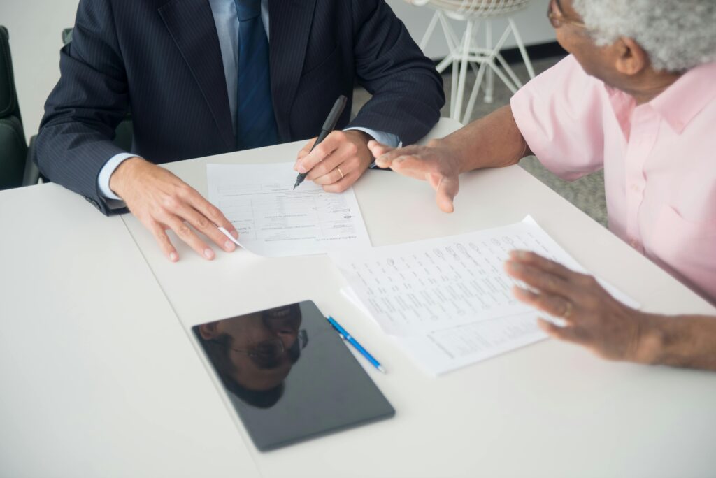 Senior woman reviewing senior living community pricing and care agreement paperwork together at home